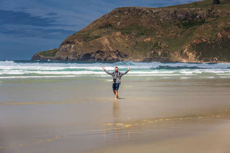 Man walking barefoot near Tunnel beach at Dunedin, South island of New Zealand. Dunedin, New Zealand - December 20 2017.のeditorial素材