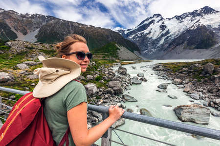 Female tourist walking along the great winding track of Hooker Valley at Mount Cook, New Zealand....