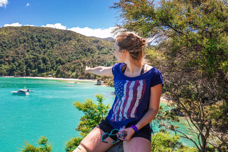 Girls resting on the rock after hiking a trail. Abel Tasman National Park, New Zealand - December 28 2017.のeditorial素材