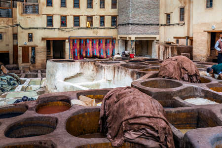 Men working in traditional leather dyeing in a traditional tanneries, Medina of Fez, Morocco. Fes, Morocco.  April 10 2016.のeditorial素材