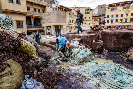 Men working in traditional leather dyeing in a traditional tanneries, Medina of Fez, Morocco. Fes,...