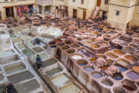 Men working in traditional leather dyeing in a traditional tanneries, Medina of Fez, Morocco. Fes, Morocco. April 10 2016.のeditorial素材