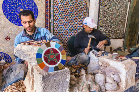 Local artisan make mosaic pieces and creating handmade items in old Medina market. Fes, Morocco -...