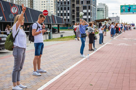 People holding flowers during peaceful protests against stolen presidential elections in Minsk,...