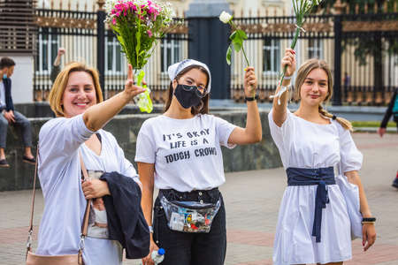 People holding flowers during peaceful protests against stolen presidential elections in Minsk,...