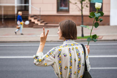 Young woman holding flower during peaceful protests against stolen presidential elections in Minsk, Belarus. Minsk, Belarus - August 15 2020.のeditorial素材