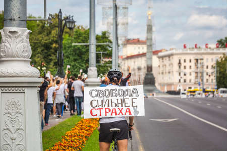 Cyclist with sign in russian "freedom more powerful than fear" during peaceful protests against stolen presidential elections in Minsk, Belarus. Minsk, Belarus - August 15 2020.のeditorial素材