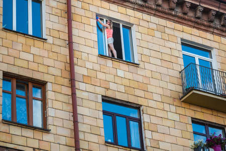 Woman washes windows during biggest peaceful protests in Belarus history against rigged presidential elections in Minsk, Belarus. Minsk, Belarus - August 16 2020.のeditorial素材