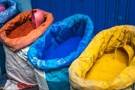 Colorful powdered pigments in sacks for sale in Chefchaouen. Blue city medina in Morocco with blue...