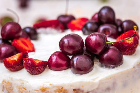 Cherries and strawberries on top of cheesecake with coconut.の写真素材