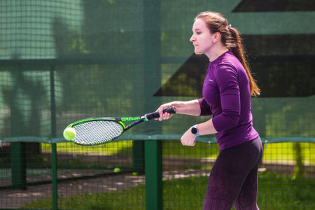 Young woman wearing purple pants, purple top and tennis shoes during professional tennis match. Minsk, Belarus - May 23 2020.のeditorial素材
