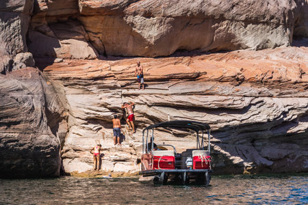 Rock climbing at Lake Powell Lone Rock at Sunset Utah USA. Page, USA - September 21, 2018.のeditorial素材