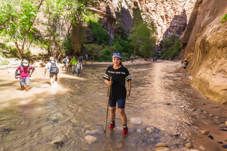 Hikers crossing river at the Zion Narrows, narrow of the Virgin River, steep faces of Zion Canyon, Zion National Park, Utah, USA. Springdale, USA - September 20, 2018.のeditorial素材