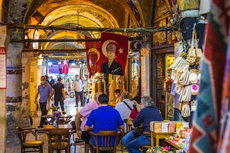 People shopping in the Grand Bazar, handmade pillows, bags and carpets are on the wall for sale. Souvenirs in famous Grand Bazaar. Istanbul, Turkey - September 30 2020.のeditorial素材