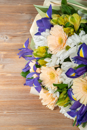 Beautiful bouquet of freesia and irises on wooden backgroundの写真素材