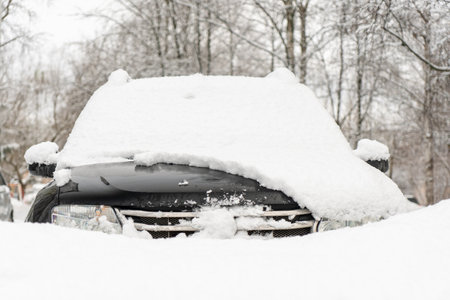 Car covered with snow in the city park. Winter holidays concept.の写真素材