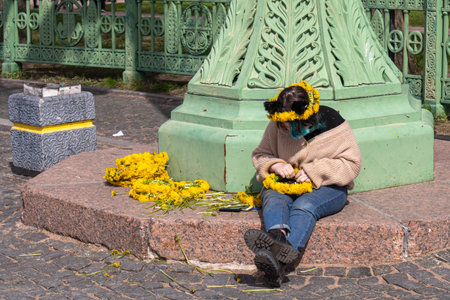 Sad woman with yellow flowers in the city park Kronstadtの写真素材