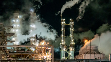 Petrochemical plant at night with smoke from chimney, Thailandの写真素材