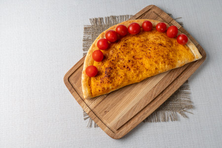Traditional georgian khachapuri with cherry tomatoes on wooden boardの写真素材