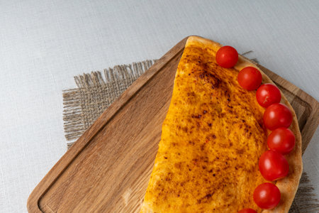 Cottage cheese casserole with cherry tomatoes on a wooden boardの写真素材