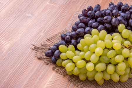 Bunch of grapes on burlap on wooden background. top viewの写真素材