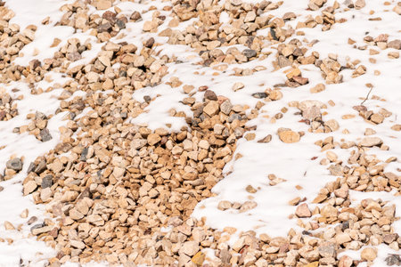 Pile of stone pebbles in the snow, winter backgroundの写真素材