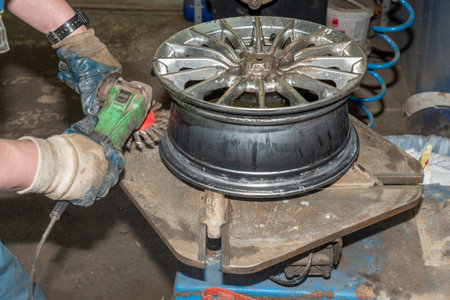 Worker with a grinder and a wheel in the workshop.の写真素材