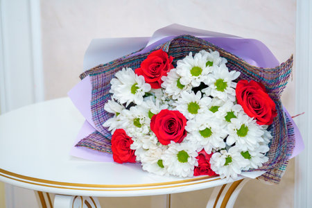 Bouquet of red and white flowers on a chair in the roomの写真素材