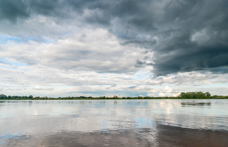 Storm clouds over the river in the summer, natural landscape background.の写真素材