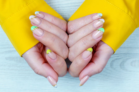 Female hands with yellow nail design. Nail polish manicure.の写真素材