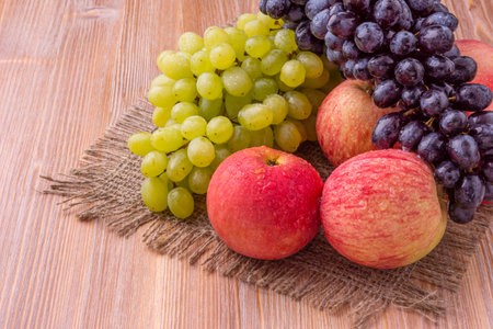 Grapes and apples on a wooden background. Healthy food.の写真素材