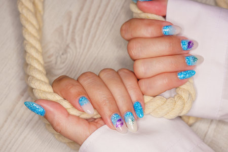 Female hands with blue nail design. Nail polish manicure. Female hands with blue nail design.の写真素材
