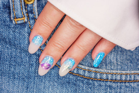 Female hand with blue nail design. Nail polish manicure.の写真素材