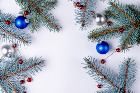 Christmas background with fir branches and blue and red balls on white backgroundの写真素材