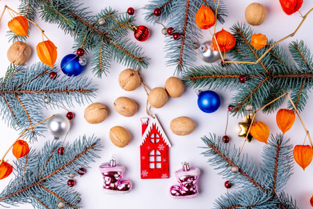 Christmas background with fir branches, red and blue balls, walnuts and gingerbread houseの写真素材