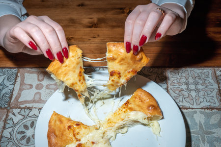 Woman's hands with red manicure hold a piece of pie.の写真素材