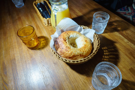 Bagel and glass of orange juice on a wooden table.