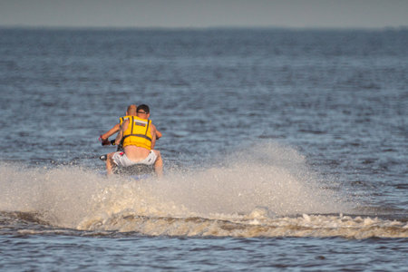 A man riding a jet ski on a lake in the evening.