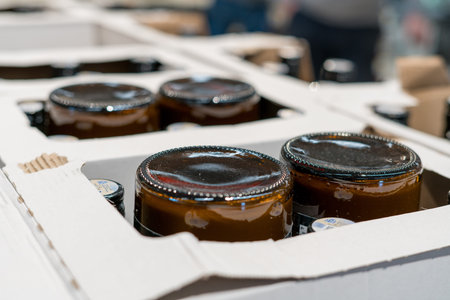 Glass jars with food product packed in cardboard box for storage and distribution. Packaging process...
