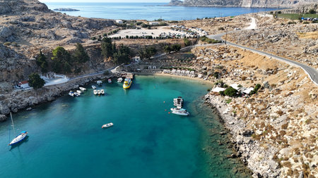 Aerial view of turquoise bay with small boats anchored near rocky coastline and Mediterranean...