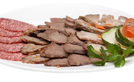 Smoked meat and sausage in cutting on plate with verdure