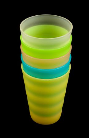 Colour plastic glasses on dark background by pileの写真素材