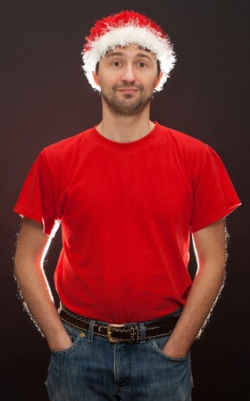 Bad santa, unshaven man in hat santa with counterohm light on dark backgroundの写真素材