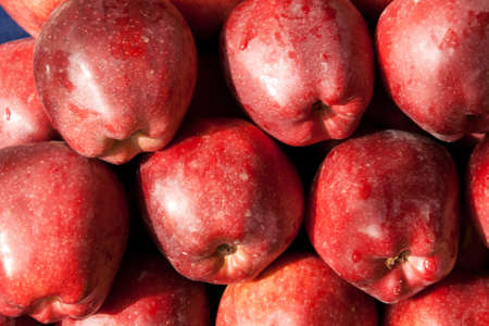 Background of red ripe apples with drops of dew