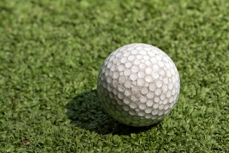 old scratched dirty golf ball on artificial turfの写真素材