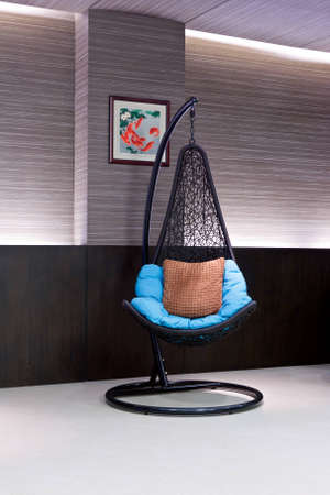 chair hanging on a chain in the hotel lobby with a blue pillowのeditorial素材