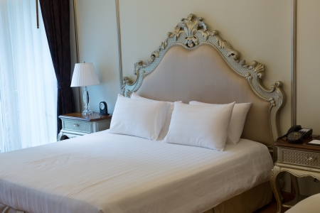 room at the luxurious double bed with carved headboard.の写真素材