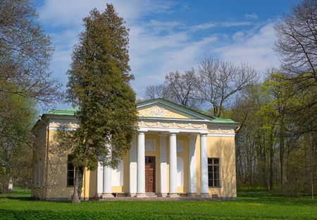 Old house with columns in the woods on a background of blue sky with cloudsの写真素材