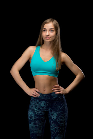 Brunette fitness woman in sportswear. In the studio, isolate on a black background.の写真素材