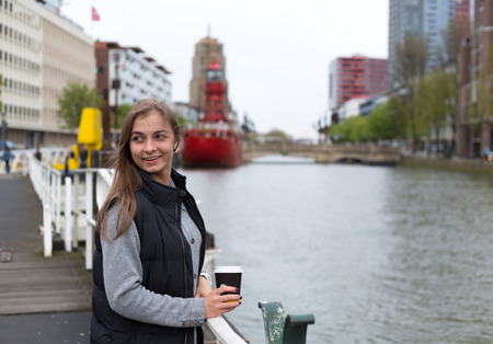 Portrait of a girl with a glass of coffee on a bridge in Rotterdam.の写真素材